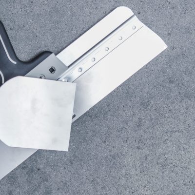 Drywall Patching Tools on the Raw Concrete Background. Construction Tools.